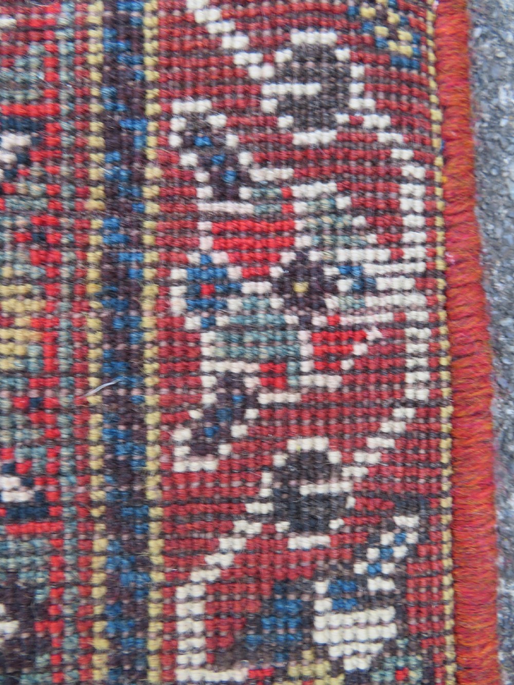 An antique hand-knotted Qashqai wool runner rug featuring repeating geometric diamond medallions in red, blue, and cream tones. View XXVII