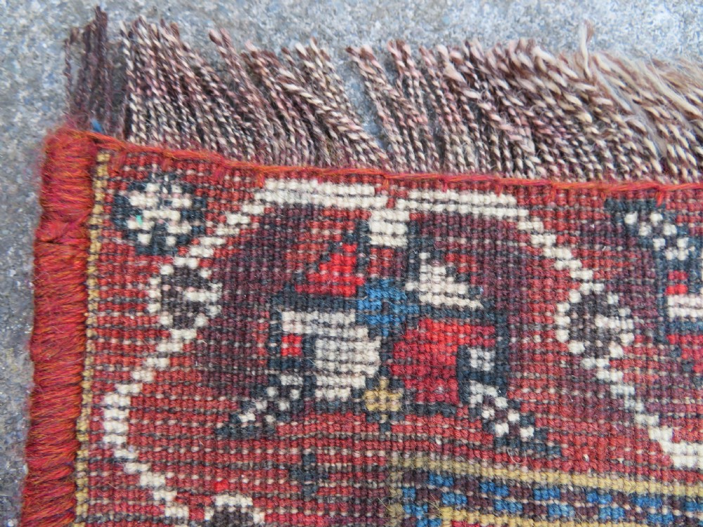 An antique hand-knotted Qashqai wool runner rug featuring repeating geometric diamond medallions in red, blue, and cream tones. View XXVIII