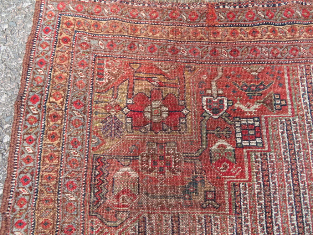 An antique hand-knotted South Persian Khamseh rug featuring a central diamond medallion surrounded by a striped field and geometric borders in shades of terracotta red, navy blue, and cream. View VIII