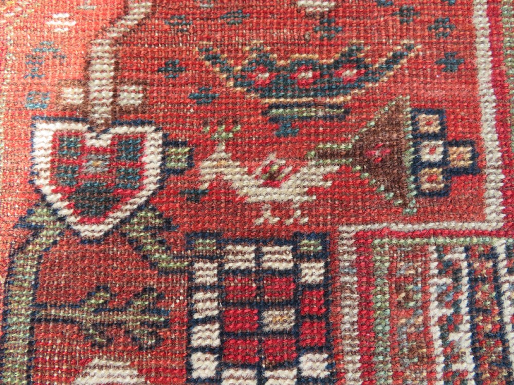 An antique hand-knotted South Persian Khamseh rug featuring a central diamond medallion surrounded by a striped field and geometric borders in shades of terracotta red, navy blue, and cream. View XI