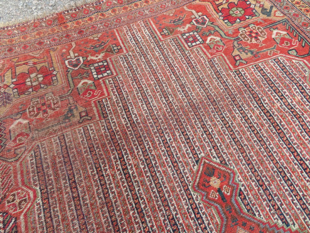 An antique hand-knotted South Persian Khamseh rug featuring a central diamond medallion surrounded by a striped field and geometric borders in shades of terracotta red, navy blue, and cream. View XVIII