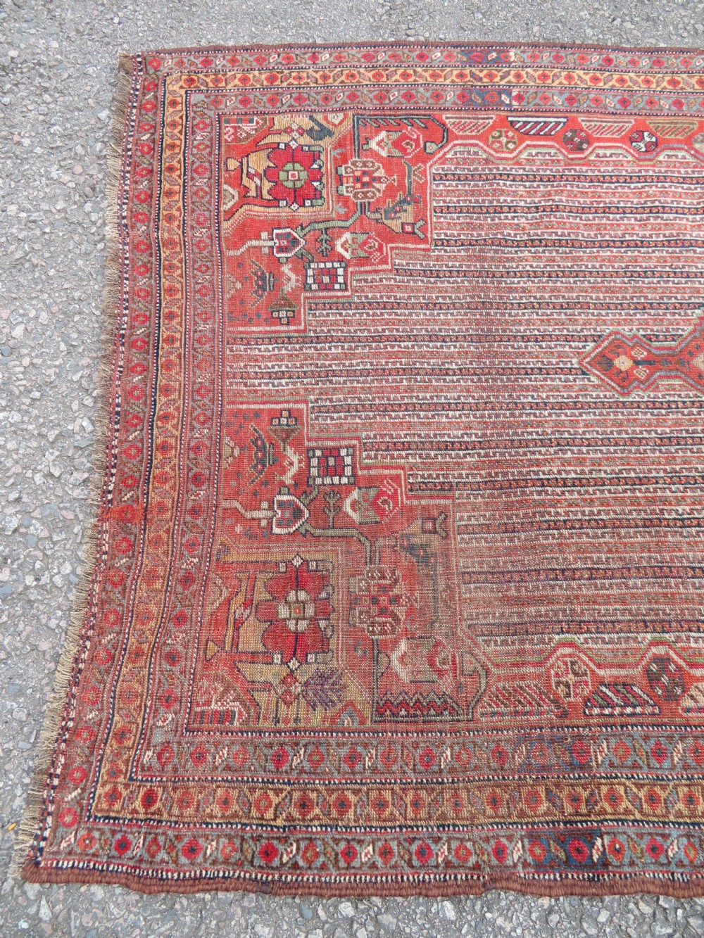 An antique hand-knotted South Persian Khamseh rug featuring a central diamond medallion surrounded by a striped field and geometric borders in shades of terracotta red, navy blue, and cream. View XXII