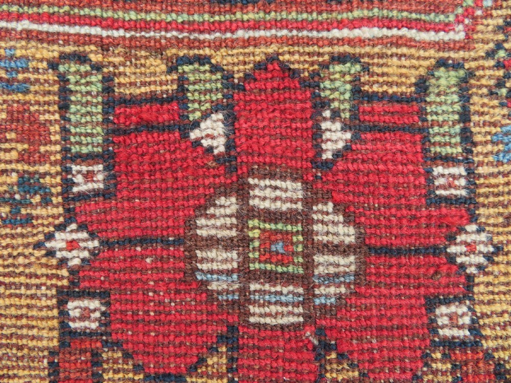 An antique hand-knotted South Persian Khamseh rug featuring a central diamond medallion surrounded by a striped field and geometric borders in shades of terracotta red, navy blue, and cream. View XXVI
