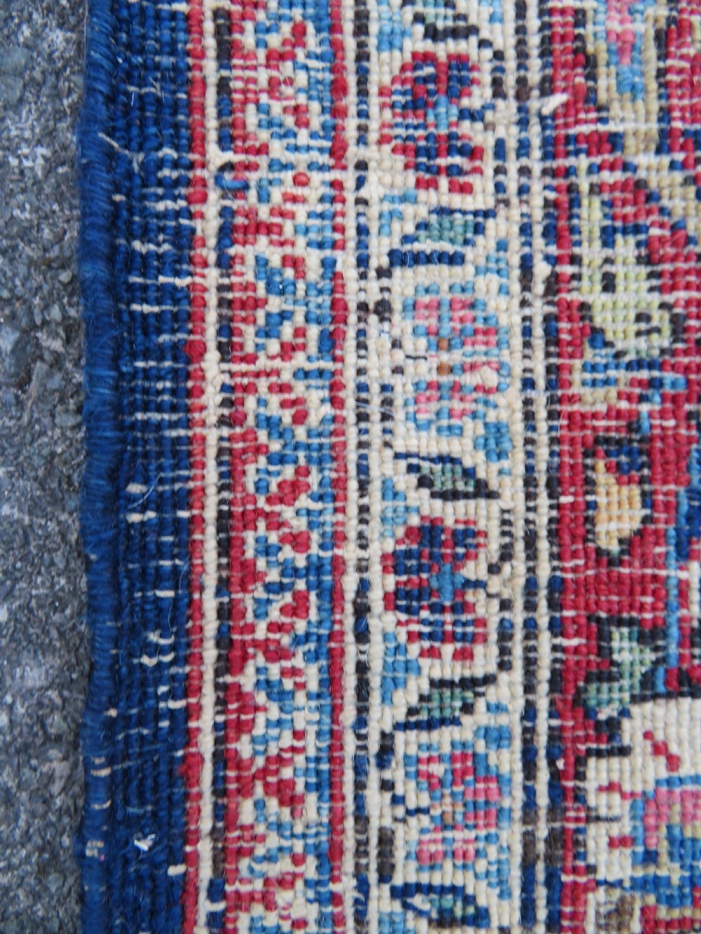 An antique hand-knotted Persian Kashan wool rug featuring a central ivory and red medallion surrounded by dense floral motifs on a dark blue field. View XXIII