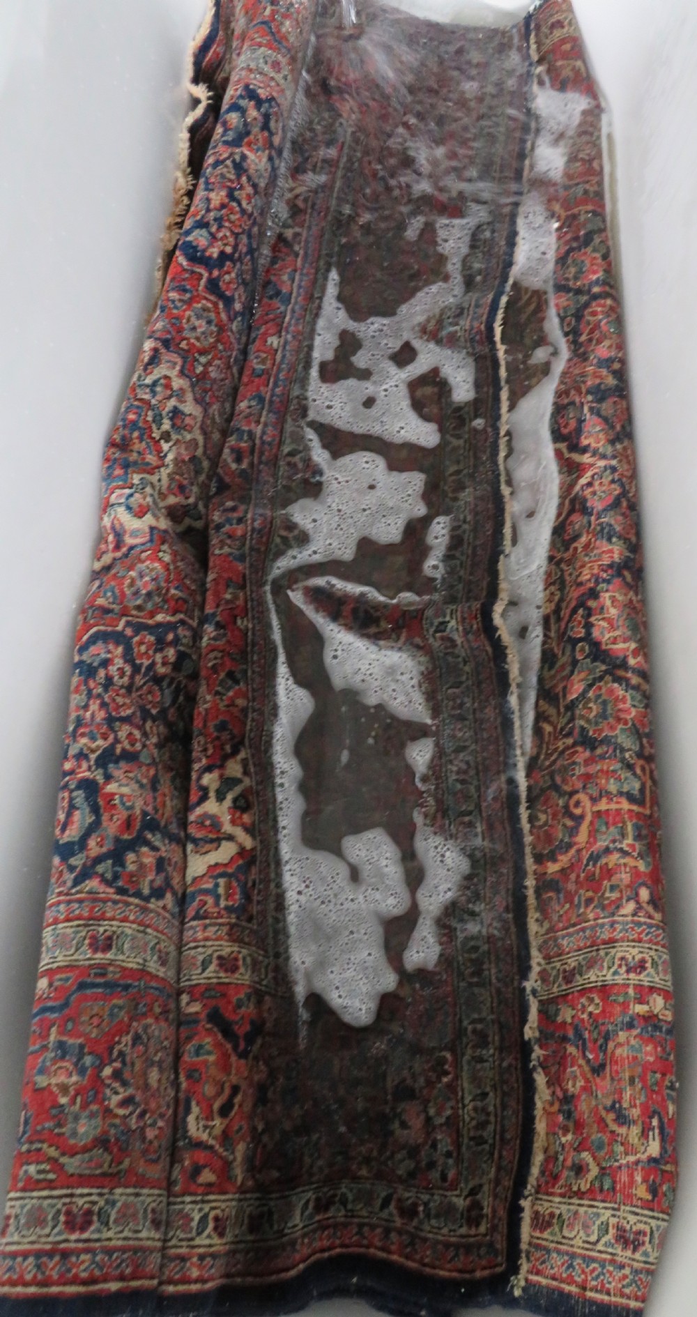 An antique hand-knotted Persian Kashan wool rug featuring a central ivory and red medallion surrounded by dense floral motifs on a dark blue field. View XXVII