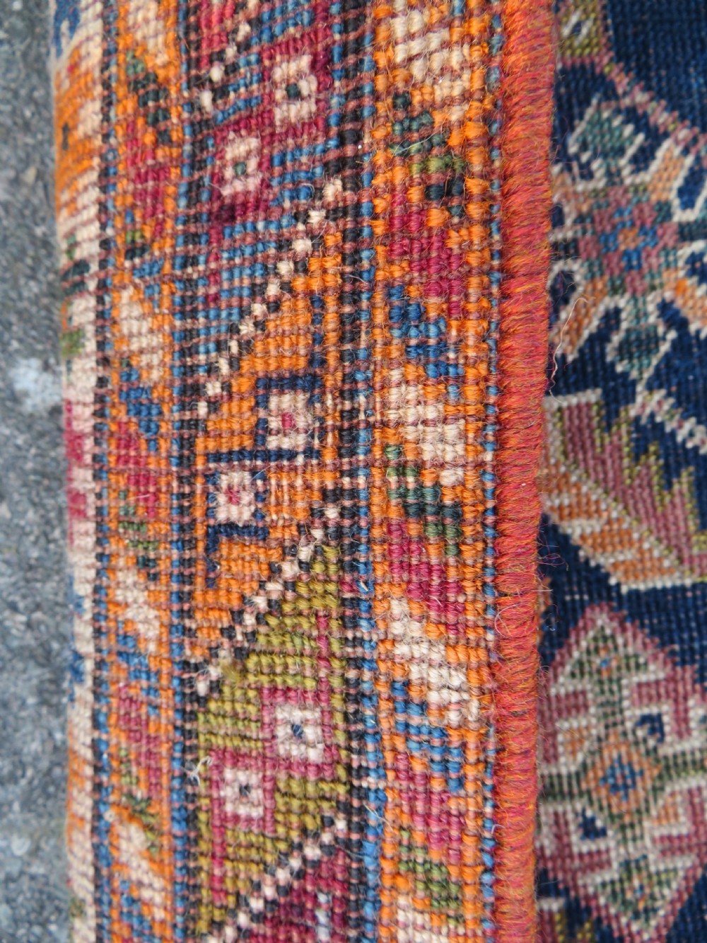 An antique Qashqai hand-knotted wool rug featuring a central diamond medallion surrounded by geometric tribal motifs in shades of navy blue, terracotta red, and cream. View XIV