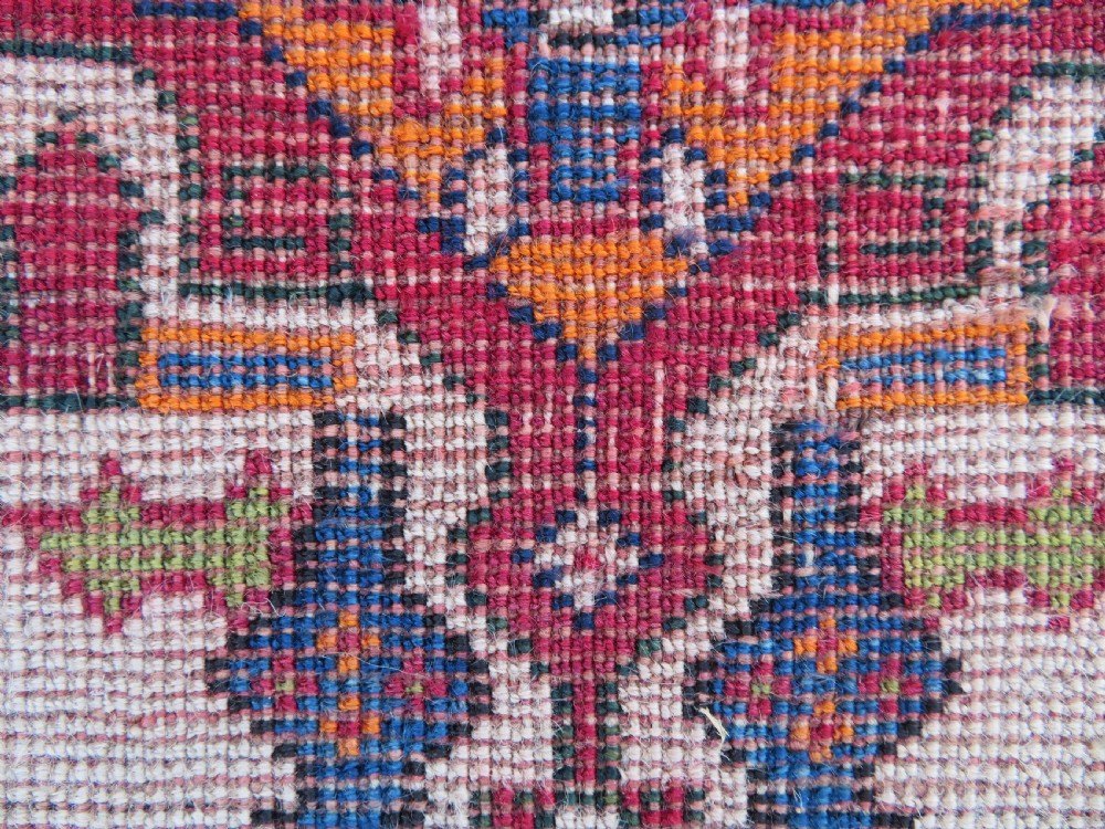 An antique Qashqai hand-knotted wool rug featuring a central diamond medallion surrounded by geometric tribal motifs in shades of navy blue, terracotta red, and cream. View XXV