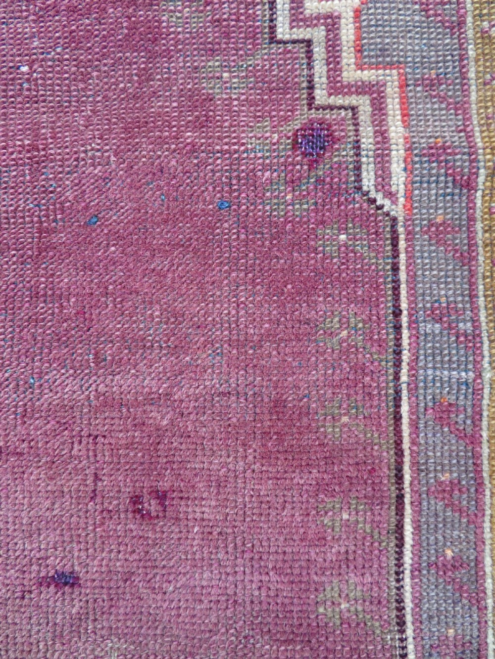 A late 19th-century hand-knotted Anatolian prayer rug featuring a deep magenta mihrab motif framed by geometric patterned borders in cream, ochre, and purple tones. View VIII