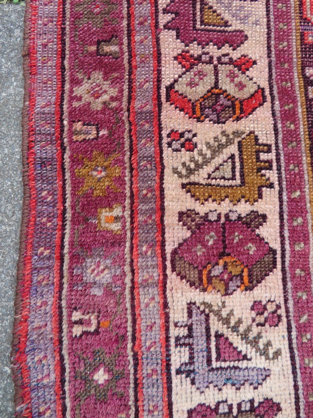 A late 19th-century hand-knotted Anatolian prayer rug featuring a deep magenta mihrab motif framed by geometric patterned borders in cream, ochre, and purple tones. View XIII