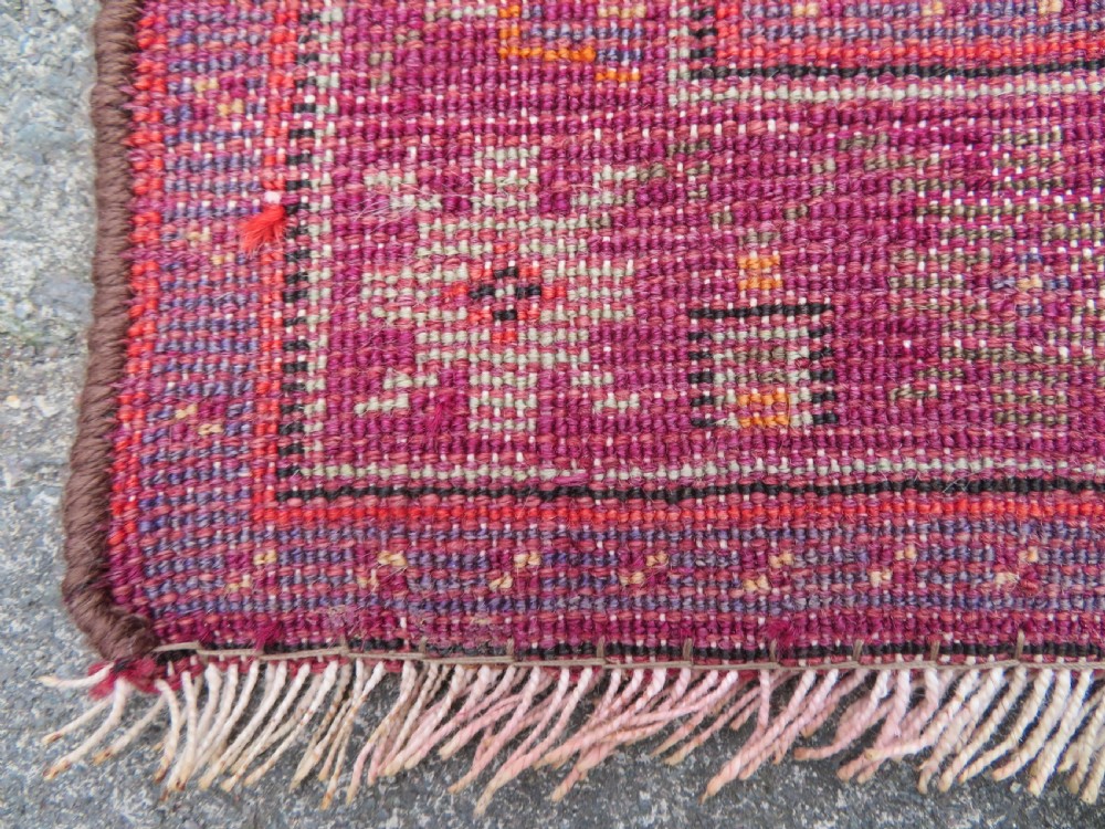 A late 19th-century hand-knotted Anatolian prayer rug featuring a deep magenta mihrab motif framed by geometric patterned borders in cream, ochre, and purple tones. View XV