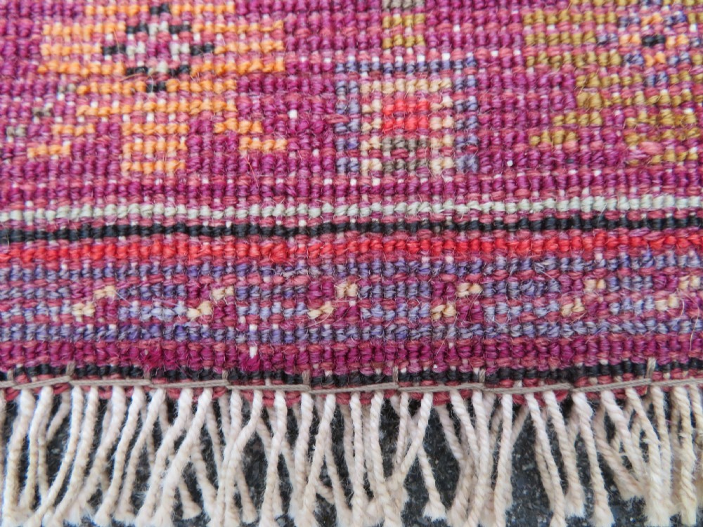 A late 19th-century hand-knotted Anatolian prayer rug featuring a deep magenta mihrab motif framed by geometric patterned borders in cream, ochre, and purple tones. View XVI