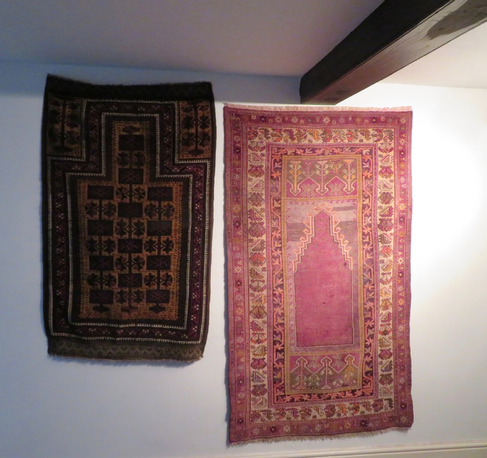 A late 19th-century hand-knotted Anatolian prayer rug featuring a deep magenta mihrab motif framed by geometric patterned borders in cream, ochre, and purple tones. View XIX