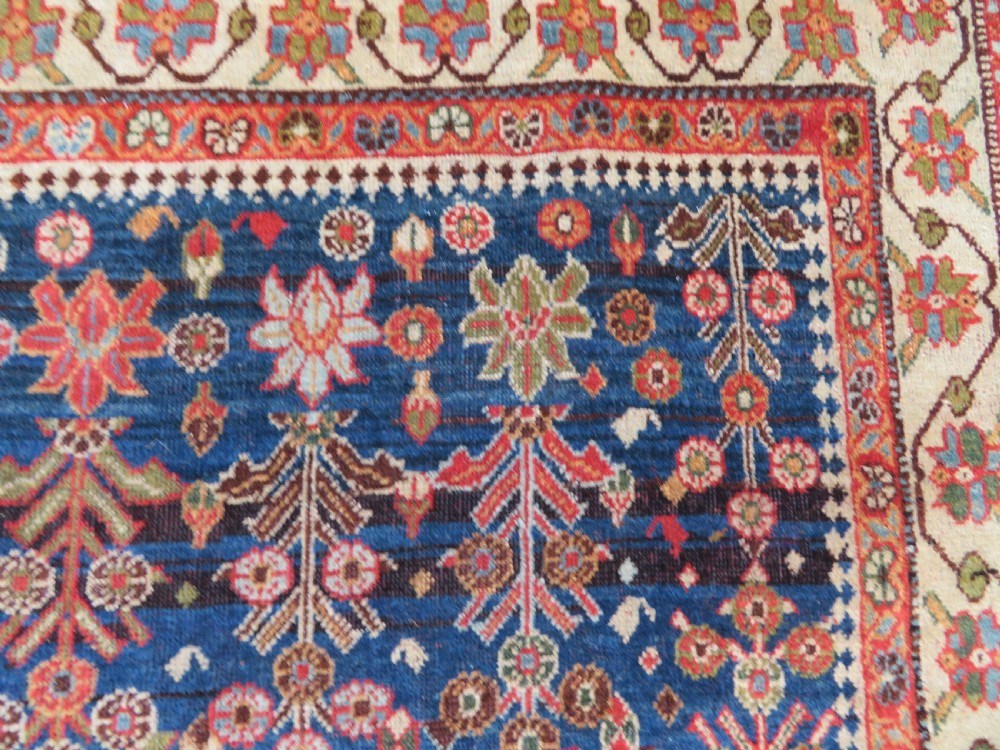 An antique Persian Qashqai Kashkuli wool rug featuring repeating boteh patterns on a deep indigo blue field surrounded by intricate cream and terracotta floral borders. View VIII