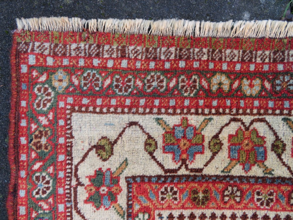 An antique Persian Qashqai Kashkuli wool rug featuring repeating boteh patterns on a deep indigo blue field surrounded by intricate cream and terracotta floral borders. View IX