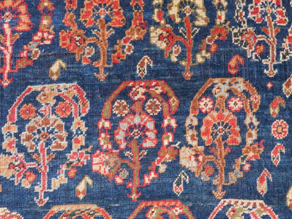 An antique Persian Qashqai Kashkuli wool rug featuring repeating boteh patterns on a deep indigo blue field surrounded by intricate cream and terracotta floral borders. View XIV
