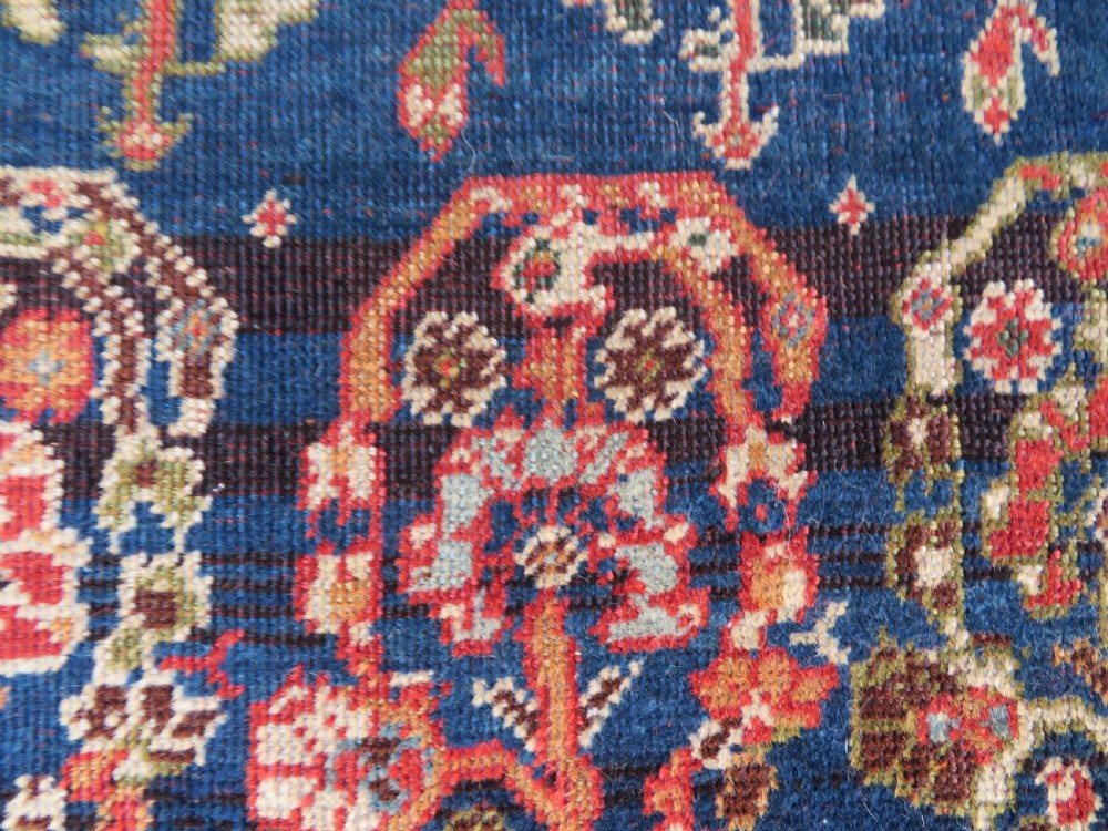 An antique Persian Qashqai Kashkuli wool rug featuring repeating boteh patterns on a deep indigo blue field surrounded by intricate cream and terracotta floral borders. View XVII