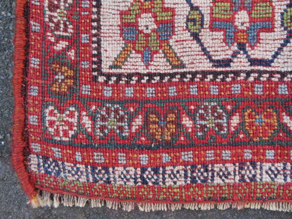 An antique Persian Qashqai Kashkuli wool rug featuring repeating boteh patterns on a deep indigo blue field surrounded by intricate cream and terracotta floral borders. View XXI