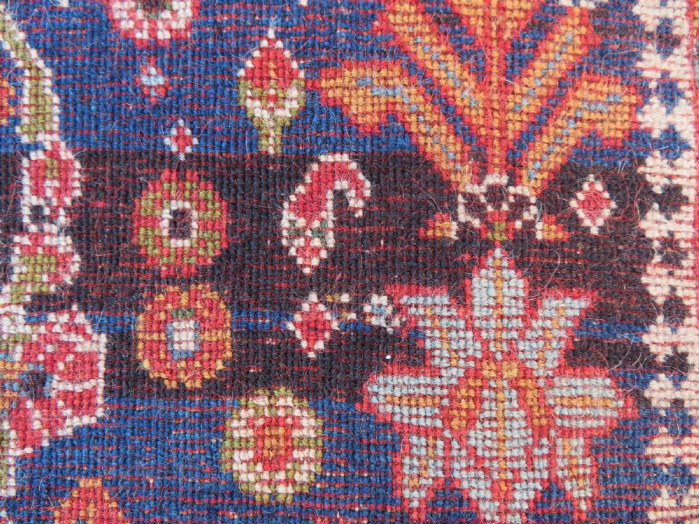 An antique Persian Qashqai Kashkuli wool rug featuring repeating boteh patterns on a deep indigo blue field surrounded by intricate cream and terracotta floral borders. View XXIII