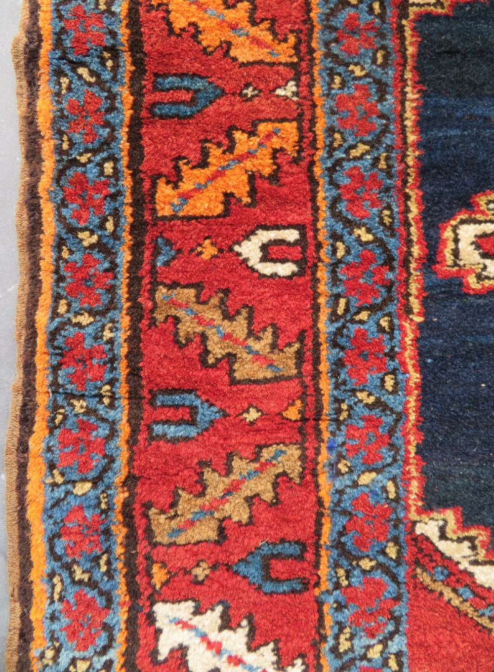 A long antique Persian Kelardasht runner rug featuring geometric diamond medallions on a dark navy blue central field framed by red and blue patterned borders. View VII