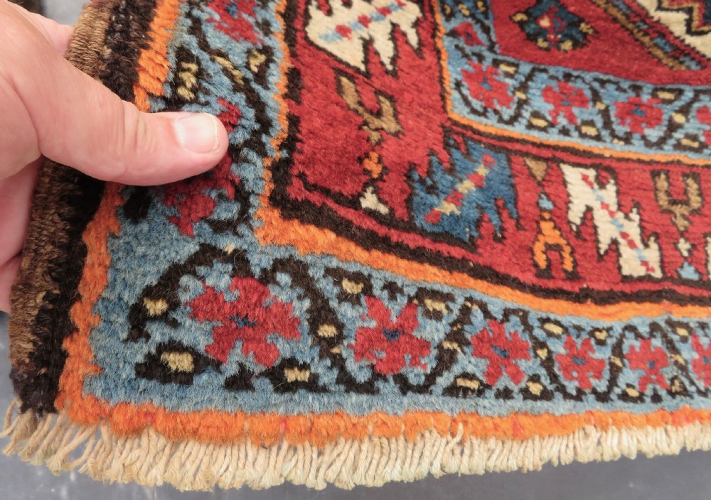 A long antique Persian Kelardasht runner rug featuring geometric diamond medallions on a dark navy blue central field framed by red and blue patterned borders. View IX