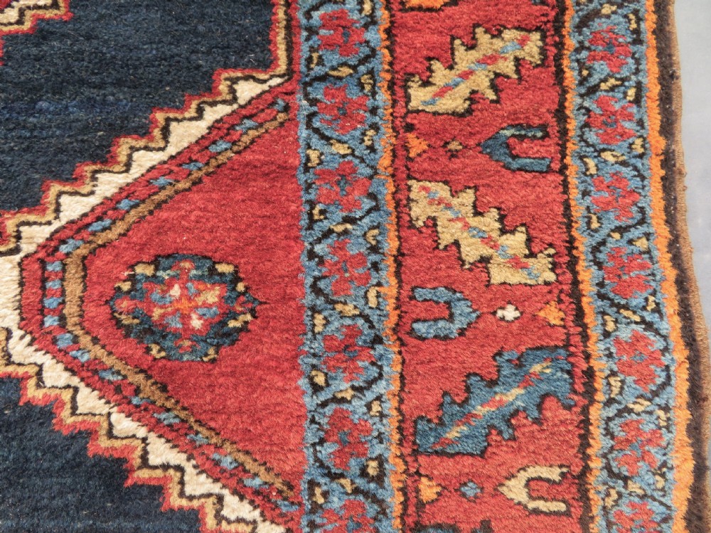 A long antique Persian Kelardasht runner rug featuring geometric diamond medallions on a dark navy blue central field framed by red and blue patterned borders. View XI