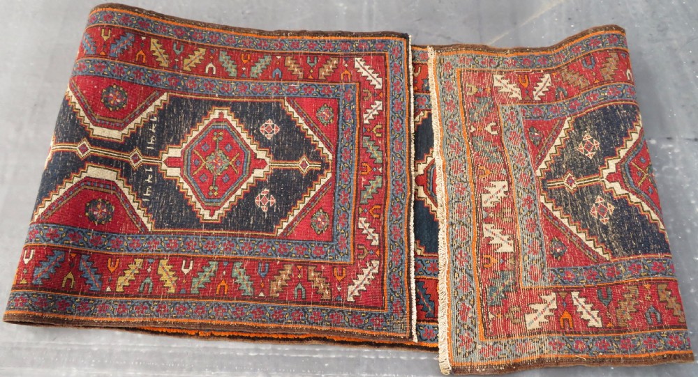 A long antique Persian Kelardasht runner rug featuring geometric diamond medallions on a dark navy blue central field framed by red and blue patterned borders. View XVII