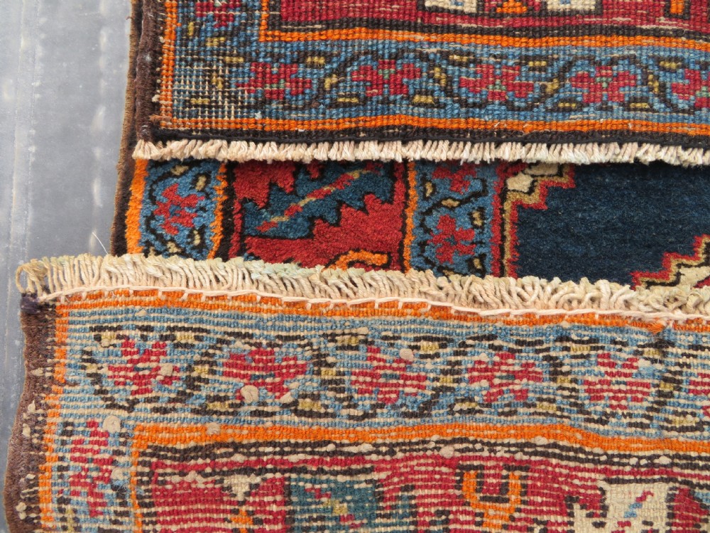 A long antique Persian Kelardasht runner rug featuring geometric diamond medallions on a dark navy blue central field framed by red and blue patterned borders. View XVIII