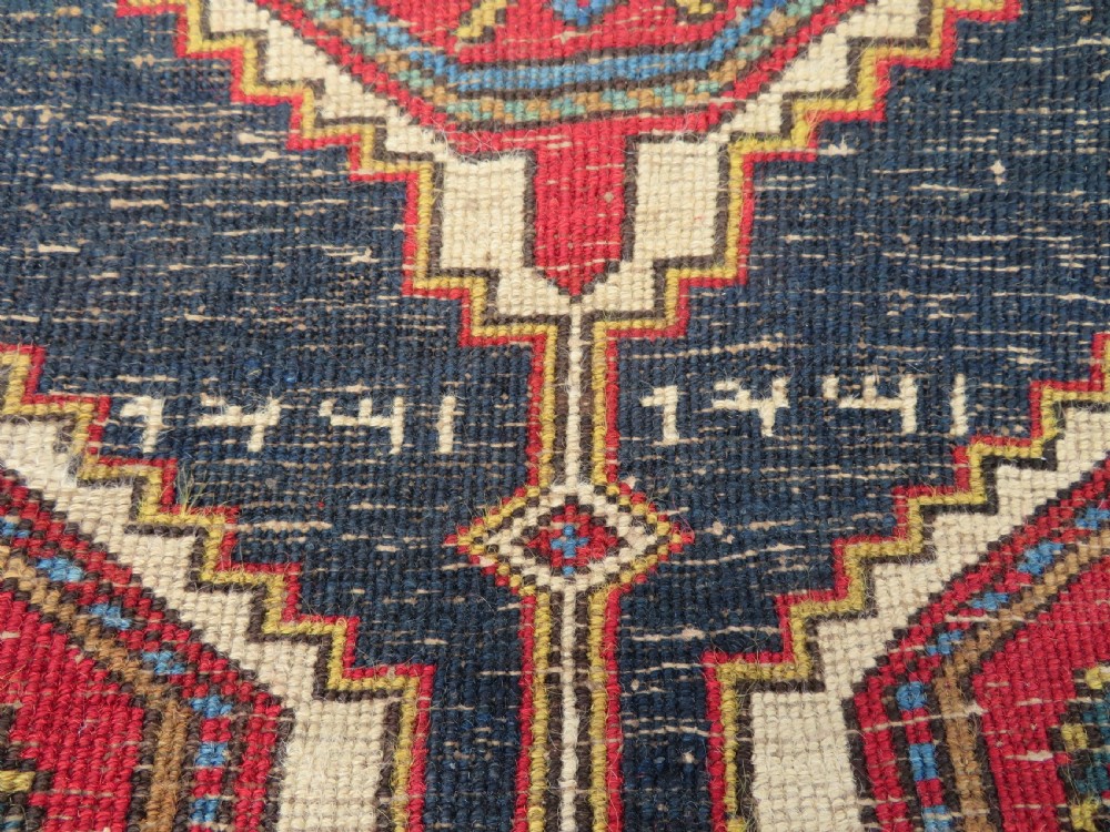 A long antique Persian Kelardasht runner rug featuring geometric diamond medallions on a dark navy blue central field framed by red and blue patterned borders. View XIX