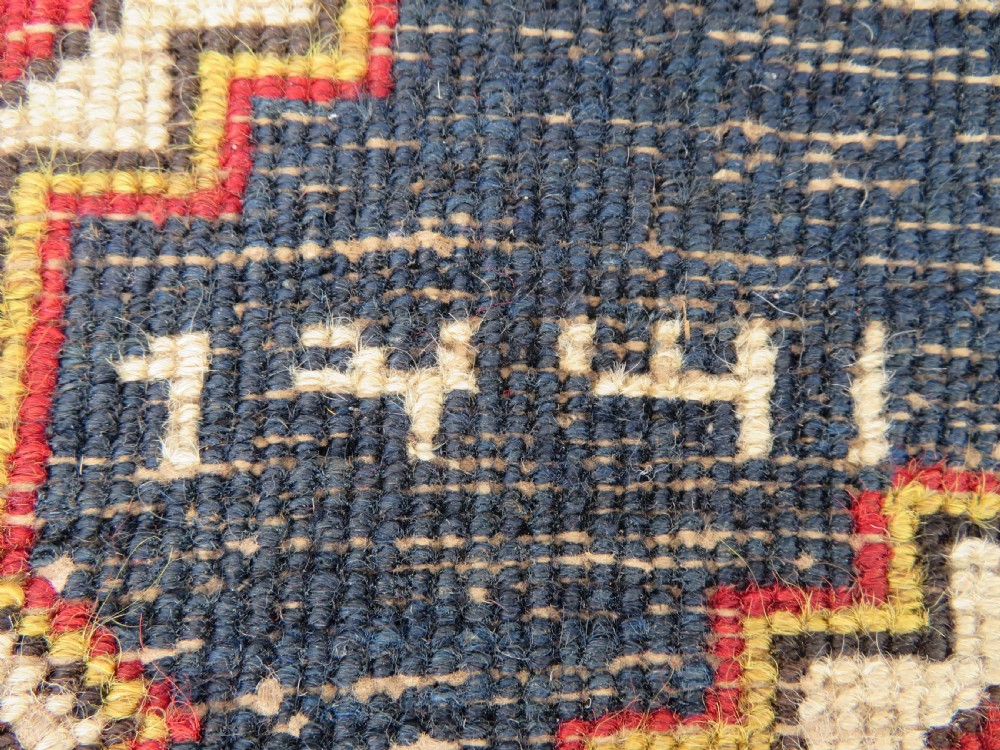 A long antique Persian Kelardasht runner rug featuring geometric diamond medallions on a dark navy blue central field framed by red and blue patterned borders. View XX