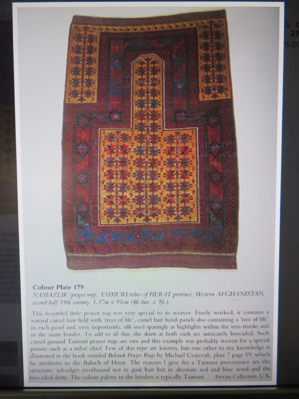 An antique Baluch wool prayer rug featuring a stepped arched mihrab design on a camel-coloured field with deep red and navy geometric motifs. View XXV
