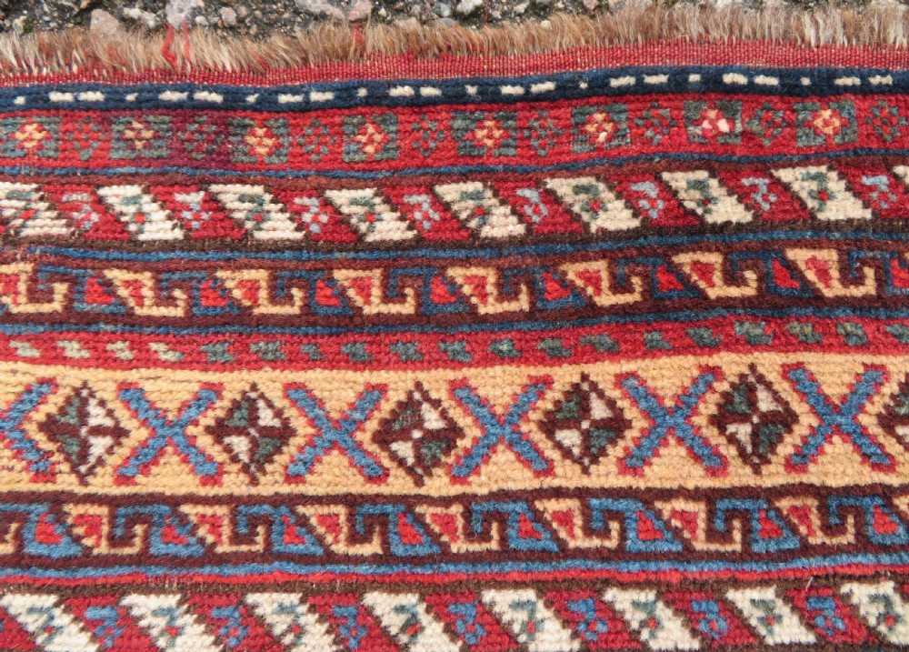 A late 19th-century Persian Qashqai hand-knotted wool rug featuring a navy blue field filled with stylized red peacock motifs, a central cream diamond medallion, and a wide red geometric border. View XXIII