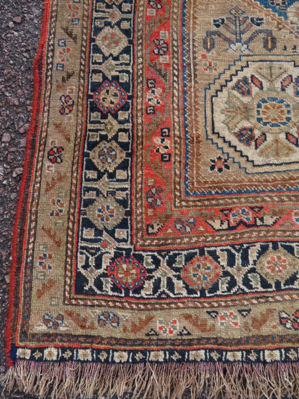 An antique Persian Qashqai Millefleurs wool rug featuring a central arch field filled with dense floral motifs in navy blue, terracotta, and ochre tones. View XI