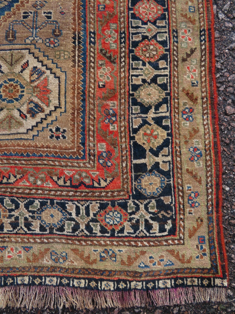 An antique Persian Qashqai Millefleurs wool rug featuring a central arch field filled with dense floral motifs in navy blue, terracotta, and ochre tones. View XII