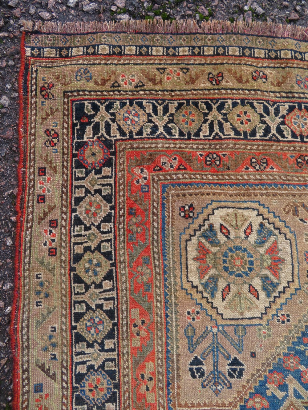 An antique Persian Qashqai Millefleurs wool rug featuring a central arch field filled with dense floral motifs in navy blue, terracotta, and ochre tones. View XIII