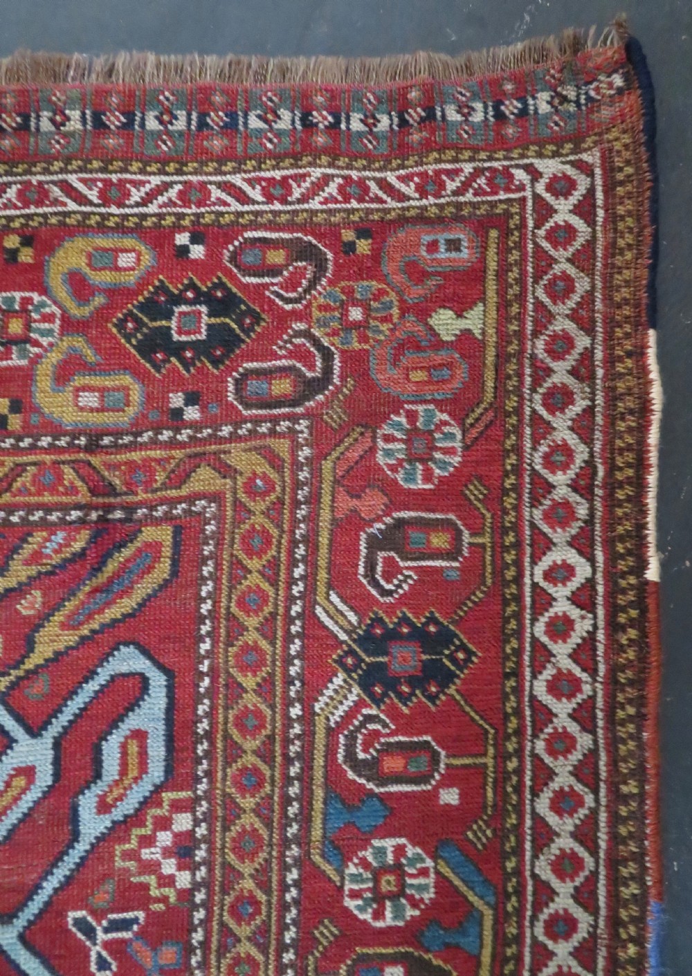 An antique hand-woven Persian Khamseh wool rug featuring a central geometric medallion with tribal bird motifs in red, navy blue, and ivory tones. View XII
