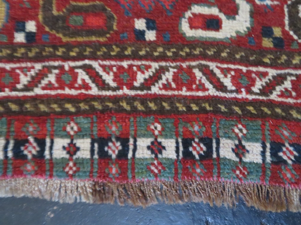An antique hand-woven Persian Khamseh wool rug featuring a central geometric medallion with tribal bird motifs in red, navy blue, and ivory tones. View XVI
