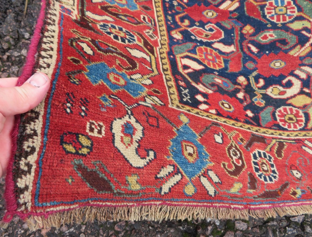A long hand-knotted Persian Khamseh rug with a navy blue field filled with repeating floral and boteh motifs, framed by a patterned red border. View VI