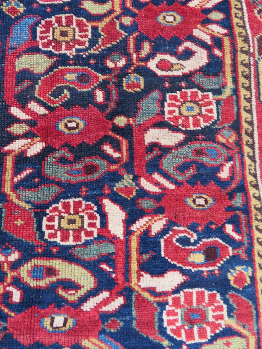 A long hand-knotted Persian Khamseh rug with a navy blue field filled with repeating floral and boteh motifs, framed by a patterned red border. View VII