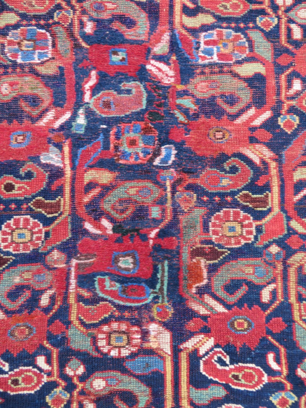 A long hand-knotted Persian Khamseh rug with a navy blue field filled with repeating floral and boteh motifs, framed by a patterned red border. View IX