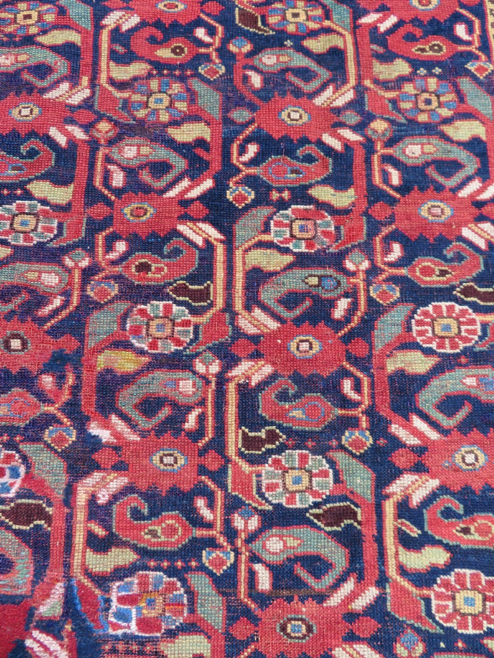 A long hand-knotted Persian Khamseh rug with a navy blue field filled with repeating floral and boteh motifs, framed by a patterned red border. View XI