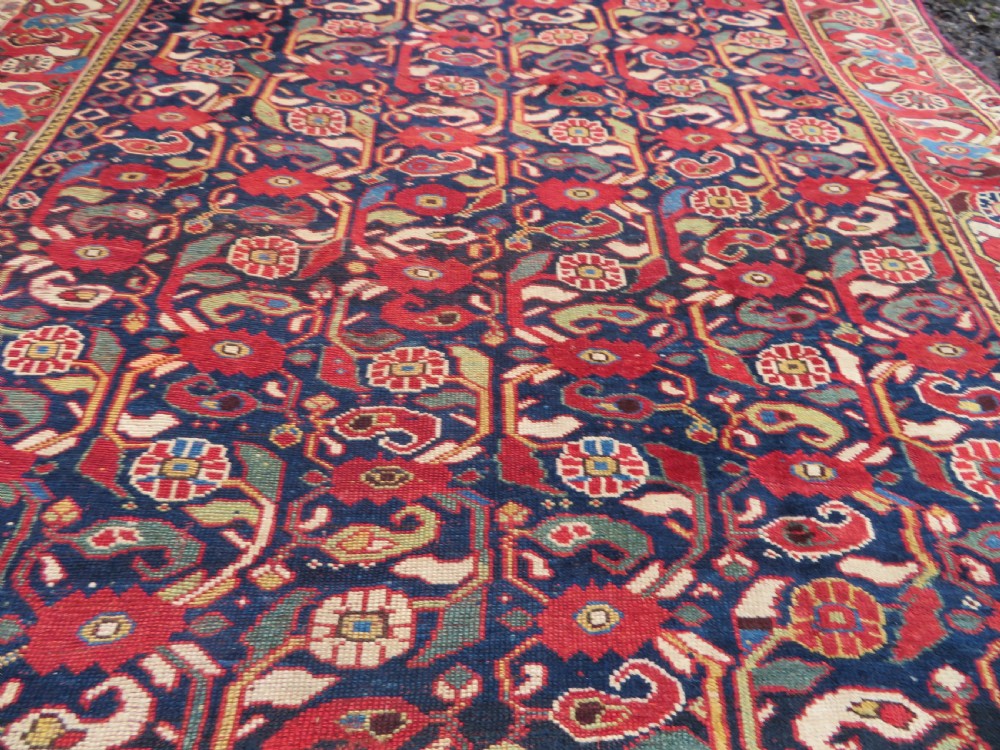 A long hand-knotted Persian Khamseh rug with a navy blue field filled with repeating floral and boteh motifs, framed by a patterned red border. View XVI