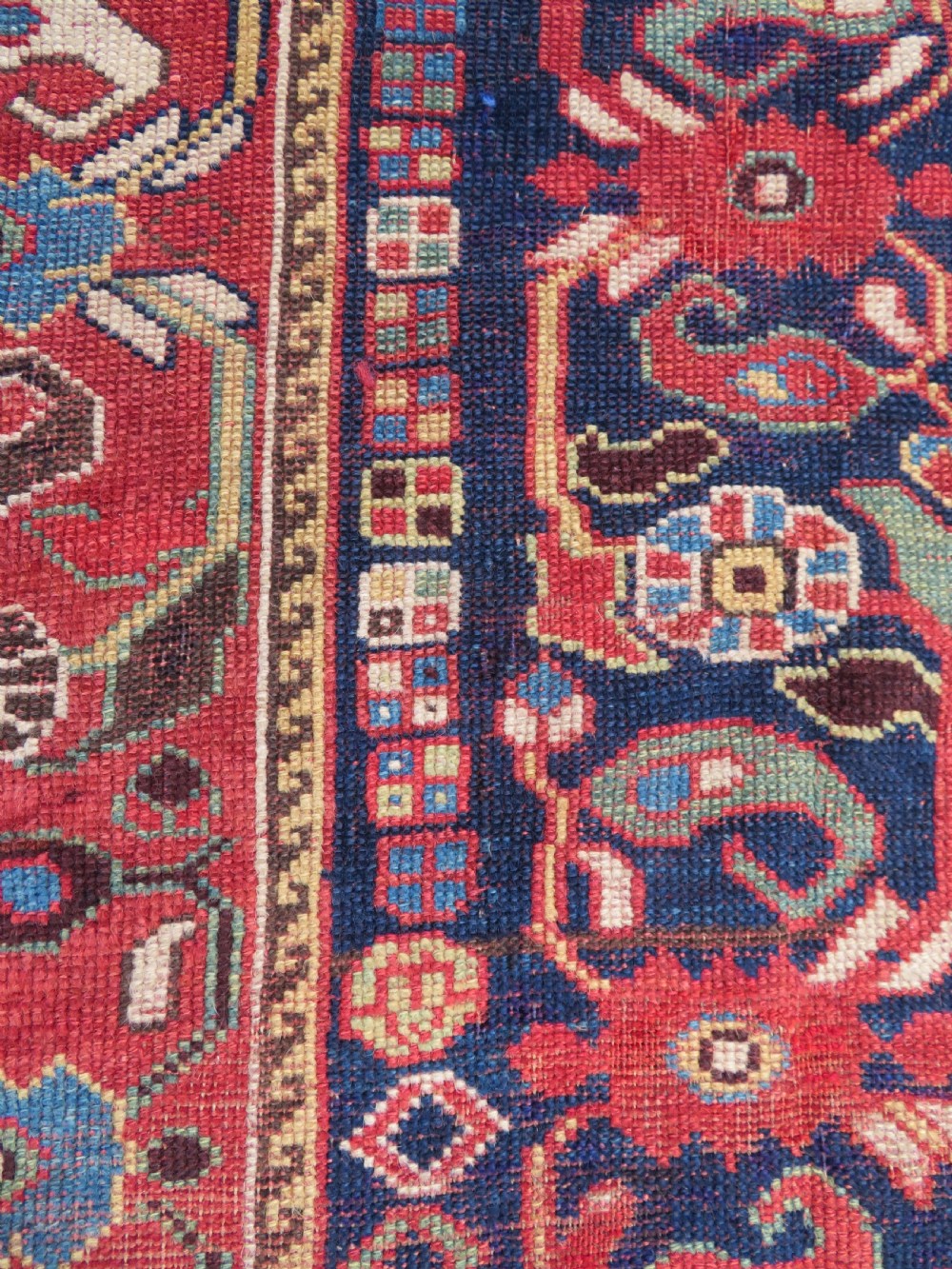 A long hand-knotted Persian Khamseh rug with a navy blue field filled with repeating floral and boteh motifs, framed by a patterned red border. View XVIII