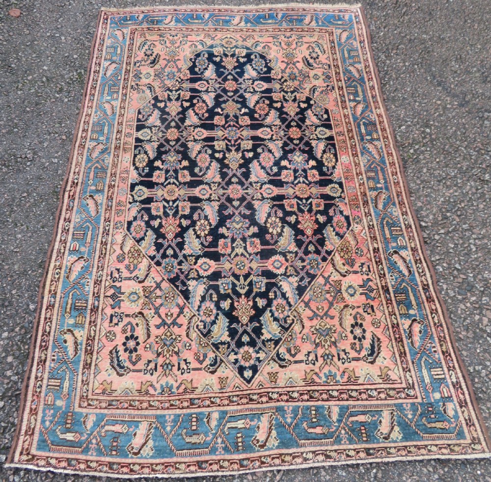 A hand-knotted Bidjar Persian rug featuring a navy blue diamond medallion, salmon pink spandrels, and multi-layered blue floral borders.