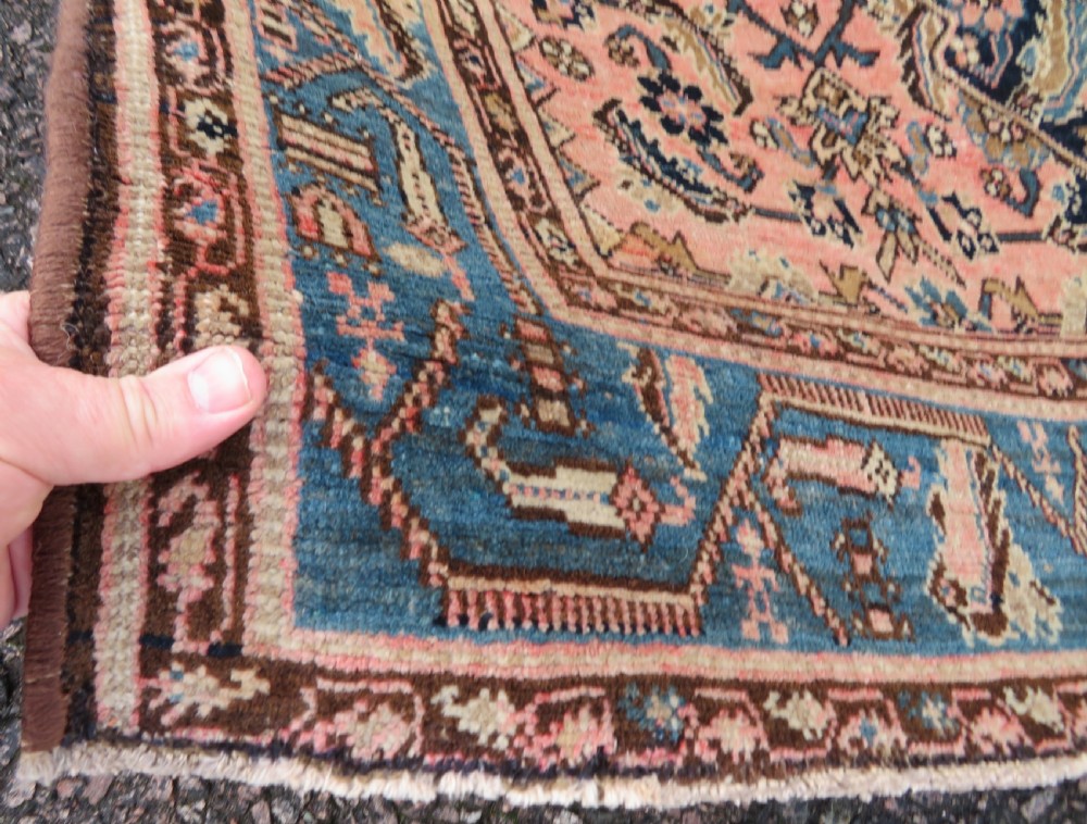 A hand-knotted Bidjar Persian rug featuring a navy blue diamond medallion, salmon pink spandrels, and multi-layered blue floral borders. View V