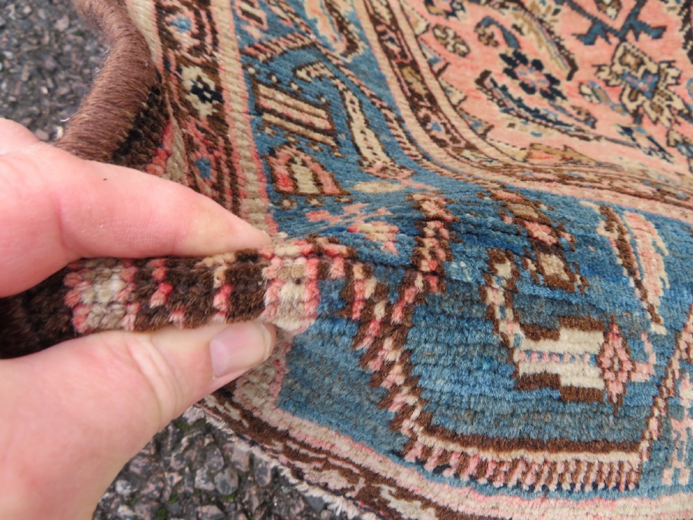 A hand-knotted Bidjar Persian rug featuring a navy blue diamond medallion, salmon pink spandrels, and multi-layered blue floral borders. View VI