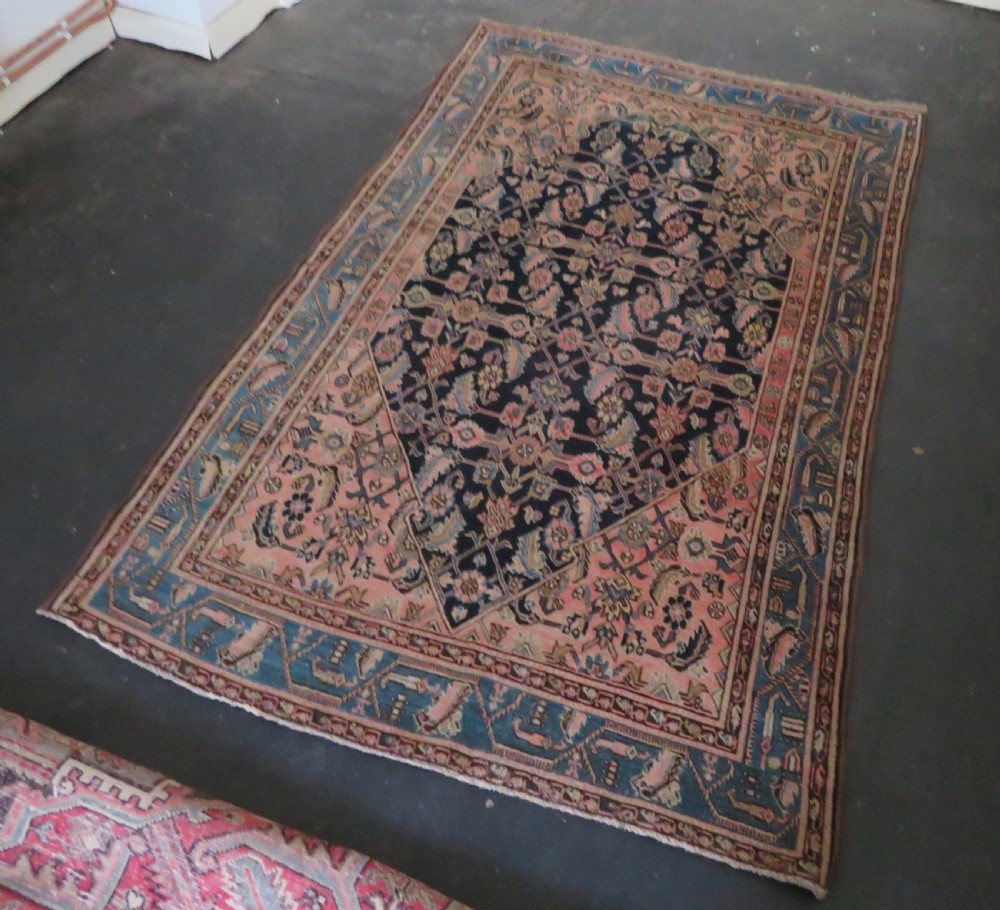 A hand-knotted Bidjar Persian rug featuring a navy blue diamond medallion, salmon pink spandrels, and multi-layered blue floral borders. View XX