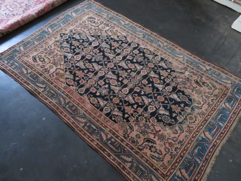 A hand-knotted Bidjar Persian rug featuring a navy blue diamond medallion, salmon pink spandrels, and multi-layered blue floral borders. View XXI