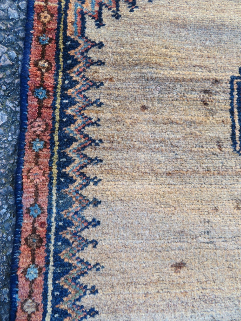 A long, narrow hand-knotted antique Persian Kurdish wool runner rug with geometric central column motifs on a camel field bordered in dark navy blue. View XI