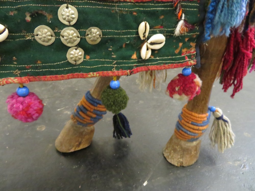 A large carved hardwood model of a standing horse decorated with detailed woven textiles, tassels, and cowrie shells. View XIII