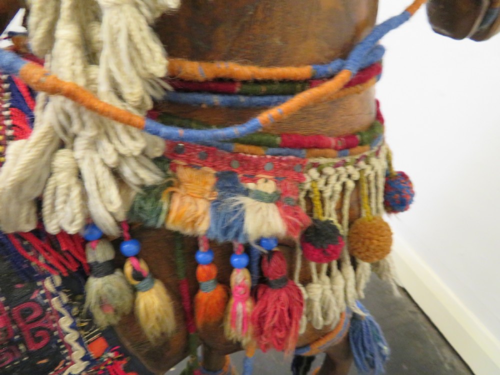 A large carved hardwood model of a standing horse decorated with detailed woven textiles, tassels, and cowrie shells. View XVII